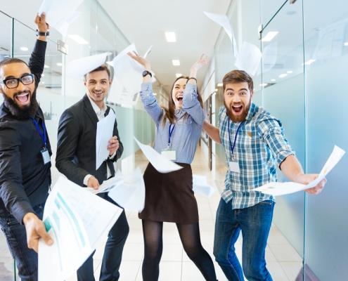 Group-of-joyful-excited-business-people-throwing-papers-and-having-fun-in-office