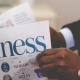 Blog header image of a businessman reading the business news for 13 recommended CPM software tools for effective KPI management blog from Solver